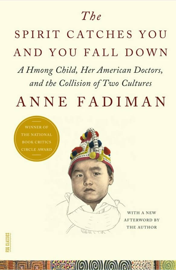 Beige background. A drawing of a young person with an ornate hat, looking out. Text reading "The Spirit Catches You and You Fall Down. A Hmong Child, Her American Dreams and the Collision of Two Cultures. Anne Fadiman. With a new afterward by the author." A yellow circle with text inside it reading: "Winner of the National Book Critics Circle Award"